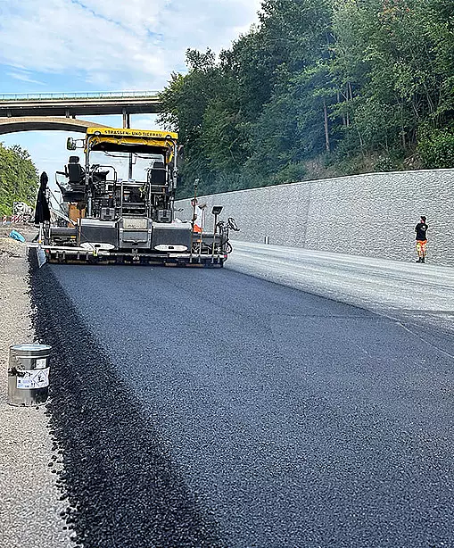 bpf Leistungsbereich Asphalt und Straße Teaser Asphalteinbau mit Straßenfertiger auf einer neu hergestellten Fahrbahn.